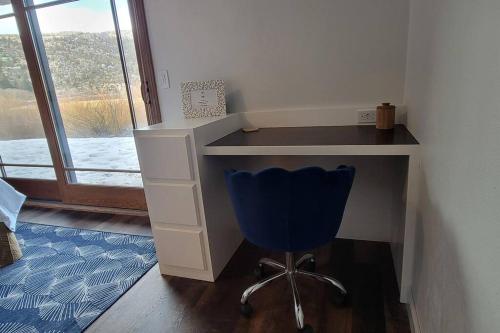 a desk with a blue chair in a room with a window at Lakefront Mountain Retreat in June Lake