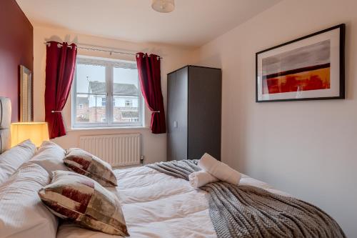Un dormitorio con una cama con almohadas. en Quiet 3 Bed House, Free EV Parking, York City en York