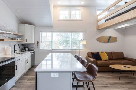Una cocina y una sala de estar con una mesa y un sofá. en Ocean Lofts in the Vibe #8 - 5 min walk to beach, en Virginia Beach