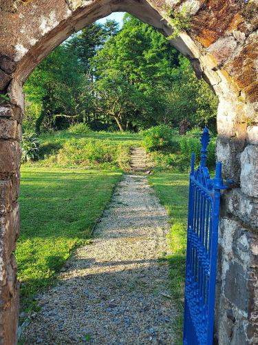 an archway in a stone wall with a blue gate at Streete retreat centre in Westmeath