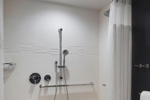 Baño blanco con ducha con cortina en Residence Inn by Marriott Lancaster en Lancaster