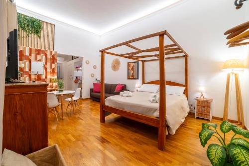 a bedroom with a canopy bed and a living room at Natoli Apartments in Palermo