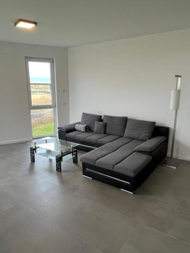 a black couch in a living room with a window at Luxus Neubauwohnung mit Blick auf den Phönix-See in Dortmund