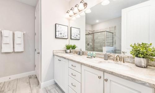 a white bathroom with a sink and a mirror at Gleaming 12 Bdrm Villa With Themed Bedrooms at Encore in Orlando