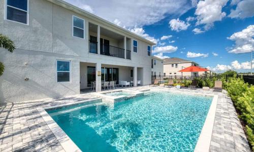 a swimming pool in front of a house at Gleaming 12 Bdrm Villa With Themed Bedrooms at Encore in Orlando