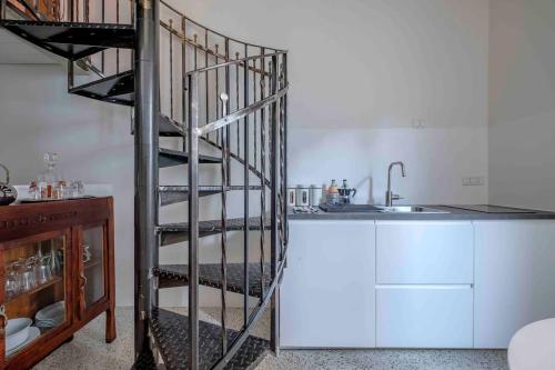 a spiral staircase in a kitchen next to a sink at La Casetta nel Cerchio in Ravenna