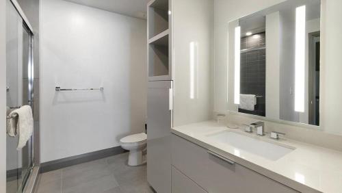 Baño blanco con lavabo y aseo en Landing Modern Apartment with Amazing Amenities (ID1381X635), en The Colony