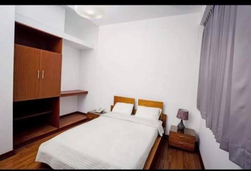 - une chambre avec un grand lit blanc et une armoire dans l'établissement HOTEL LANCELOT, à Chiclayo