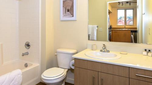 a bathroom with a toilet and a sink and a mirror at Landing Modern Apartment with Amazing Amenities (ID8493X21) in Tacoma