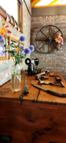 une table en bois avec des fleurs dans un vase dans l'établissement El Cobertizo, à Los Repollos