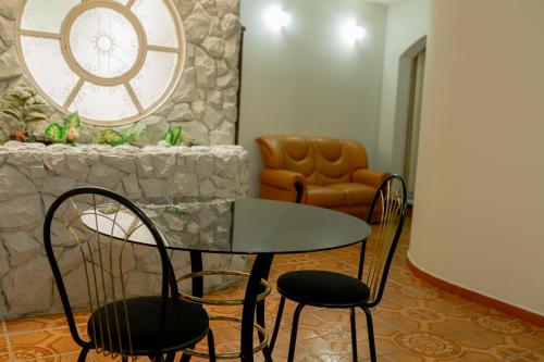 mesa y sillas en una habitación con reloj en HOTEL VILAS DOS MONTES, en Montes Claros