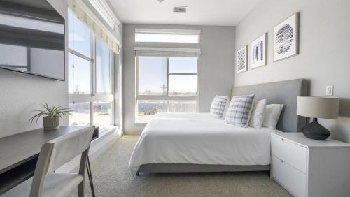 a bedroom with a bed and a desk and windows at Landing Modern Apartment with Amazing Amenities (ID1401X866) in Denver