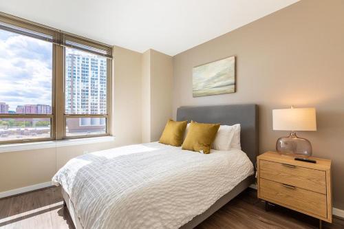 ein Schlafzimmer mit einem Bett, einer Lampe und einem Fenster in der Unterkunft Landing Modern Apartment with Amazing Amenities (ID1148) in Arlington