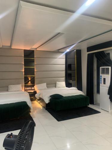 Habitación de hotel con 2 camas con cojines verdes en GT Guesthouse, en Warri