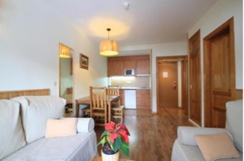 a living room with a couch and a dining room at Aparthotel Sarrato in Sallent de Gállego