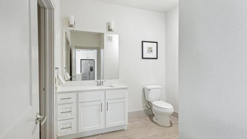 a white bathroom with a toilet and a sink at Landing Modern Apartment with Amazing Amenities (ID1011X798) in San Antonio