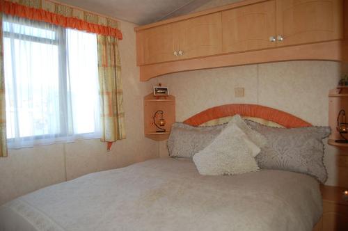 una camera con letto e finestra di Caravan 252 Bryn Y Mor Beach Side Park a Tywyn