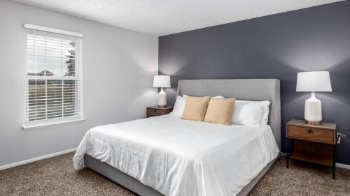 a bedroom with a large white bed with two lamps at Landing Modern Apartment with Amazing Amenities (ID9104X76) in Lewis Center