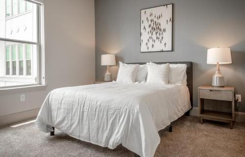 1 dormitorio con 1 cama blanca grande y 2 lámparas en Landing Modern Apartment with Amazing Amenities (ID5227) en Houston