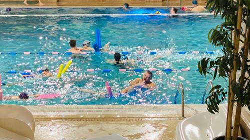 a group of people swimming in a swimming pool at Apartament modern -with Free Parking in Chiajna