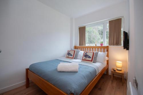 a bedroom with a bed with blue sheets and a window at Fairwinds in Sandbanks