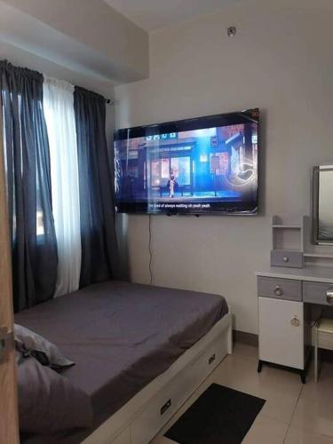 una camera con letto e TV a schermo piatto a parete di Calculated Comfort Space a Manila