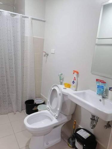 bagno con servizi igienici bianchi e lavandino di Calculated Comfort Space a Manila