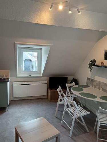 un salon avec une table et des chaises et une fenêtre dans l'établissement ch'ty breizh, à Perros-Guirec