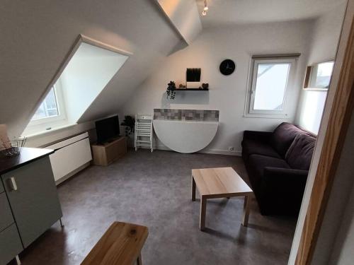 a living room with a couch and a bath tub at ch'ty breizh in Perros-Guirec