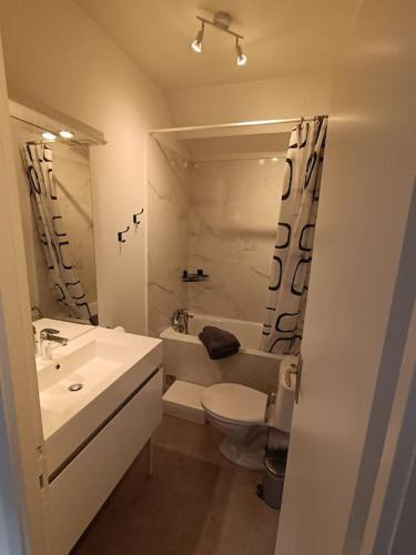 une salle de bain blanche avec un lavabo et des toilettes dans l'établissement ch'ty breizh, à Perros-Guirec