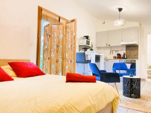 une chambre avec un lit et deux chaises et une cuisine dans l'établissement La Tiny House au bord de l'eau, à Saint-Hilaire-Saint-Mesmin