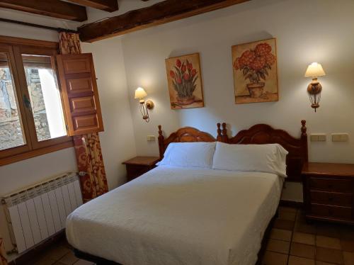 a bedroom with a large bed and a window at Hostal Posada La Panadera in Sepúlveda