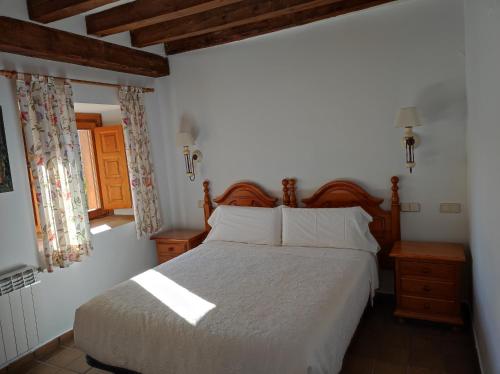 a bedroom with a large bed and a window at Hostal Posada La Panadera in Sepúlveda