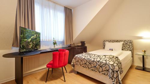 a bedroom with a bed and a desk with a computer at Hotel Erasmus - Mein Genuss- und Wellnesshotel in Trassem