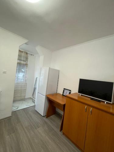 a living room with a television and a refrigerator at Apartament cu o camera in Oradea