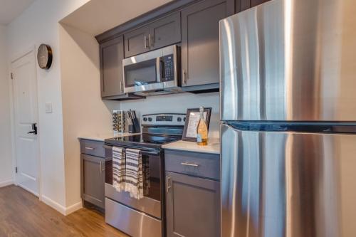 eine Küche mit einem Kühlschrank aus Edelstahl und einer Mikrowelle in der Unterkunft 1 BR 1 BA Luxury - Museum District & Downtown HTX in Houston