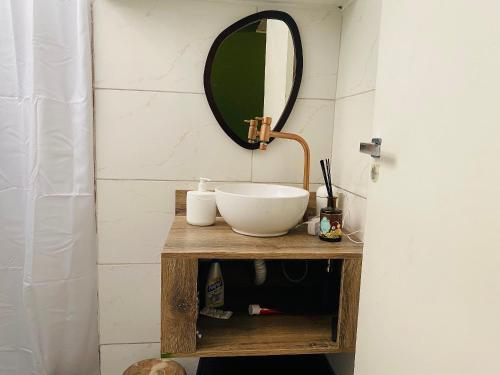 a bathroom with a sink and a mirror at Canoas Life - Comodidade e Piscina em São Conrado in Rio de Janeiro