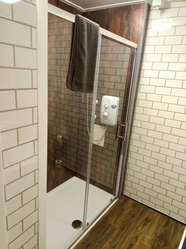 a shower with a glass door in a bathroom at The Townhouse Self Catering in Dumfries
