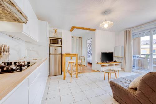 une cuisine et un salon avec un canapé et une table dans l'établissement Charmant T2 Top Emplacement avec Parking, à Montpellier