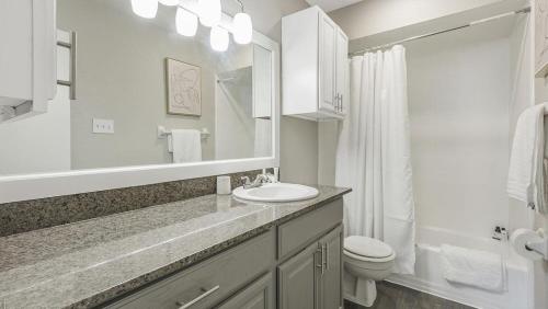 a bathroom with a sink and a toilet and a mirror at Landing Modern Apartment with Amazing Amenities (ID6036X00) in Houston