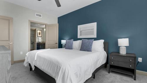 - une chambre bleue avec un lit et un mur bleu dans l'établissement Landing Modern Apartment with Amazing Amenities (ID4336X27), à La Porte