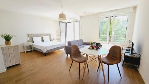 sala de estar con cama, mesa y sillas en Zenao Appart'Hotel, en Nevers