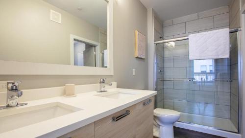 a bathroom with a sink and a toilet and a mirror at Landing Modern Apartment with Amazing Amenities (ID7744X77) in Newport