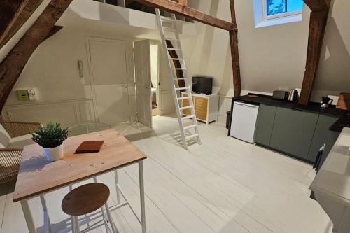 une cuisine avec une table en bois et une échelle dans l'établissement Le perchoir, studio avec mezzanine, à Arras