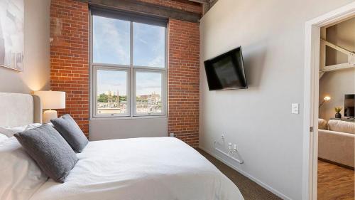 um quarto com uma cama branca e uma janela em Landing Modern Apartment with Amazing Amenities (ID9909X36) em Omaha