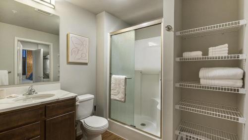 a bathroom with a shower and a toilet and a sink at Landing Modern Apartment with Amazing Amenities (ID9909X36) in Omaha