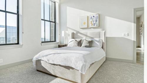 um quarto branco com uma cama grande com lençóis e almofadas brancos em Landing Modern Apartment with Amazing Amenities (ID6802X67) em Baltimore