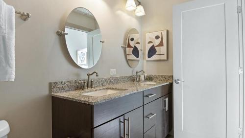 a bathroom with two sinks and two mirrors at Landing Modern Apartment with Amazing Amenities (ID6802X67) in Baltimore