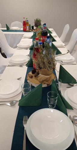 a long table with white plates and green napkins at Pokoje Gościnne "U Karola" Pracownicze in Ścinawa