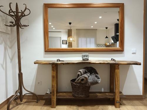a bathroom with a wooden table and a mirror at Lindo pisito in León